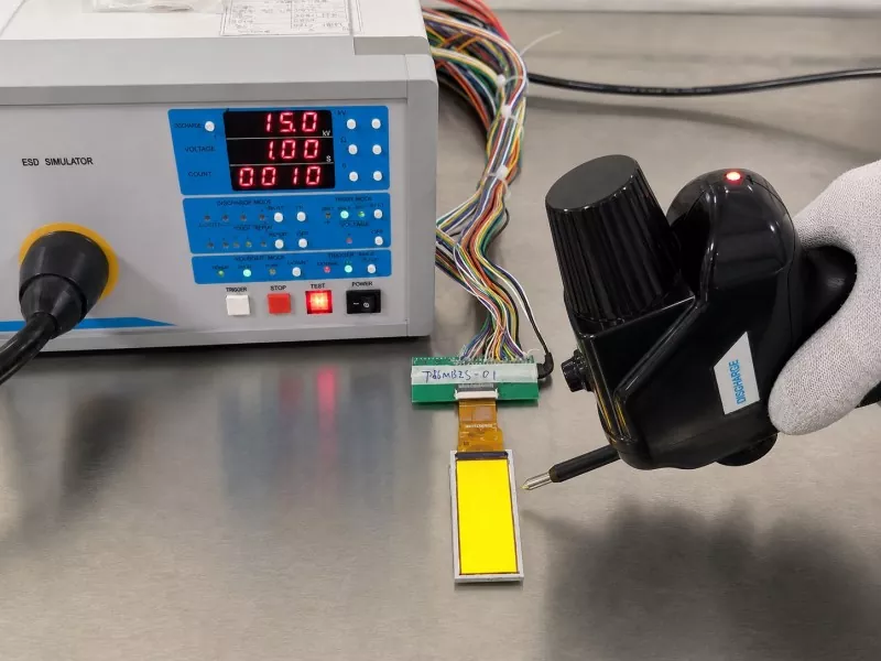 Powered 2.86-inch TFT connected to a test-jig PCB during a 15 kV air-discharge test setup